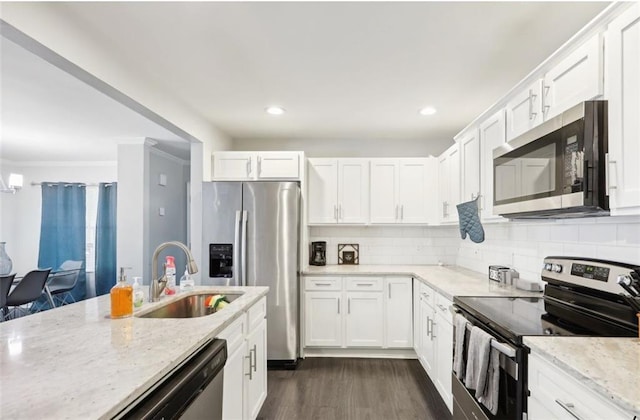 kitchen featuring tasteful backsplash, white cabinets, a sink, appliances with stainless steel finishes, and dark wood-style flooring