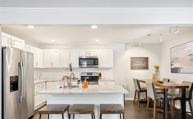 kitchen with white cabinetry, tasteful backsplash, and appliances with stainless steel finishes