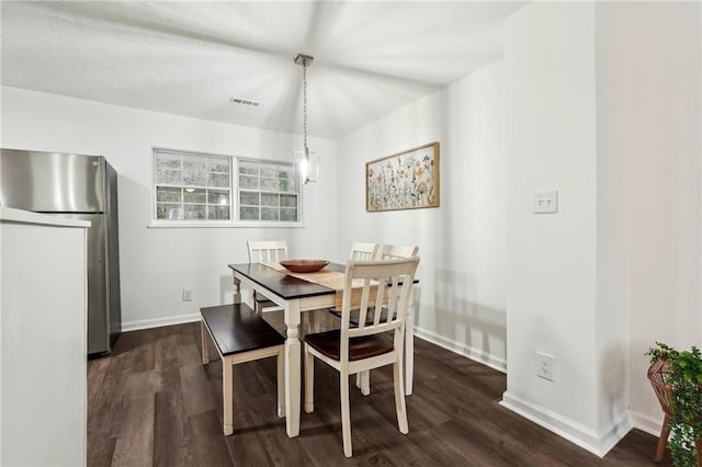 dining space featuring baseboards, visible vents, and dark wood finished floors