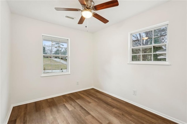 unfurnished room featuring ceiling fan, wood finished floors, visible vents, and baseboards