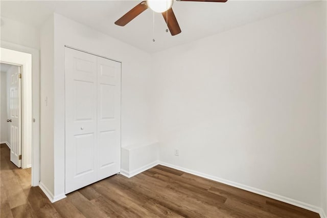 unfurnished bedroom with a ceiling fan, a closet, baseboards, and wood finished floors