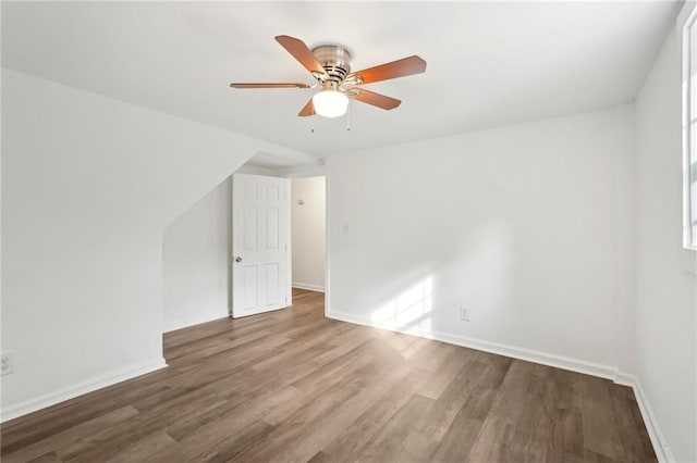 bonus room with a ceiling fan, baseboards, and wood finished floors