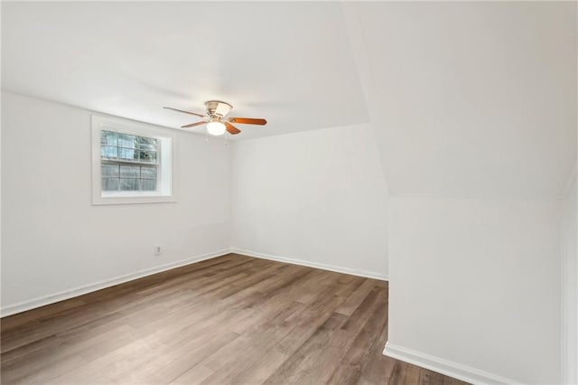 empty room featuring a ceiling fan, baseboards, and wood finished floors