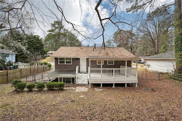 rear view of house featuring fence private yard and a wooden deck