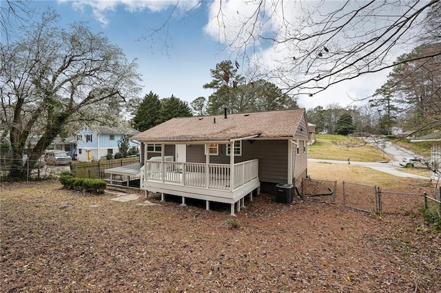 rear view of property featuring a gate, fence, a wooden deck, and central air condition unit