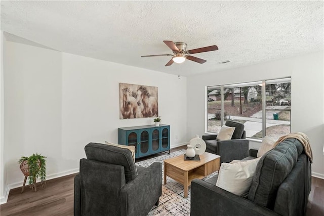 living room with baseboards, a textured ceiling, a ceiling fan, and wood finished floors