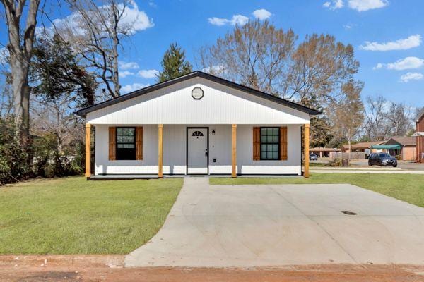 view of front of home with a front yard, covered porch, and driveway