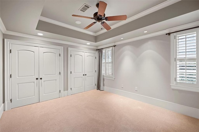 unfurnished bedroom with carpet flooring, multiple closets, multiple windows, ornamental molding, and recessed lighting