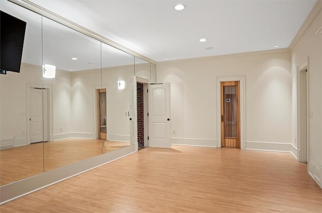empty room with light wood-style flooring, crown molding, baseboards, and recessed lighting