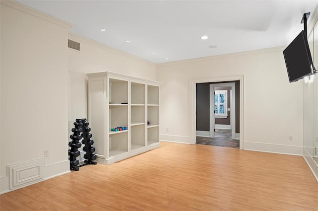 unfurnished room featuring wood finished floors, crown molding, baseboards, and recessed lighting