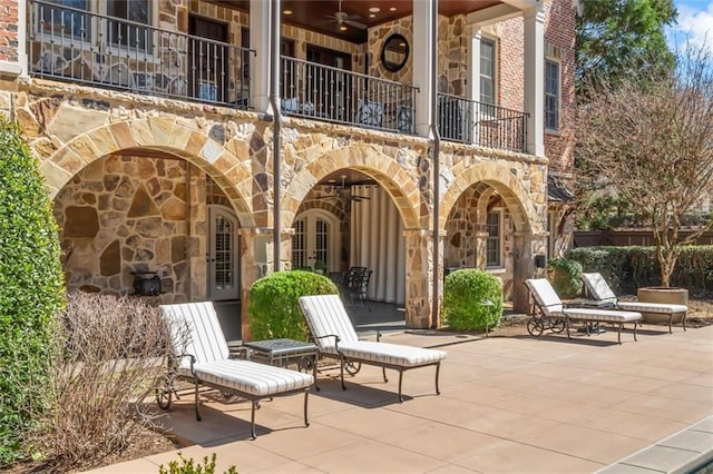 view of patio / terrace with a balcony and a ceiling fan
