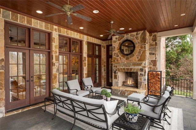 view of patio with french doors, an outdoor living space with a fireplace, and a ceiling fan