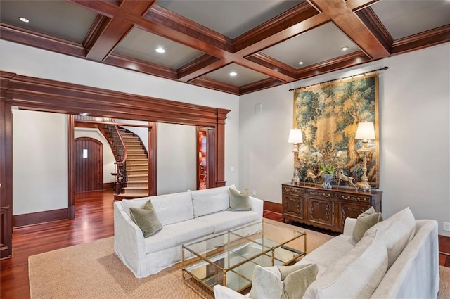 living area with arched walkways, wood finished floors, beamed ceiling, stairs, and baseboards