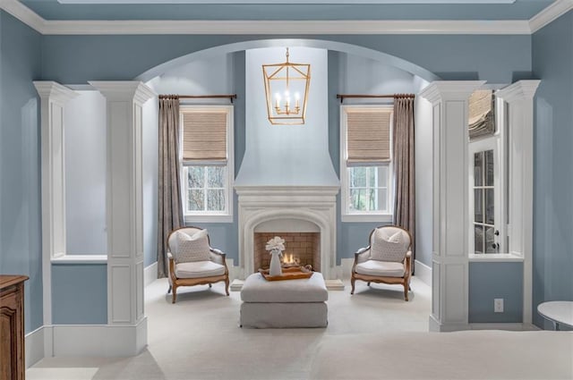 living area with carpet, a chandelier, arched walkways, and ornamental molding