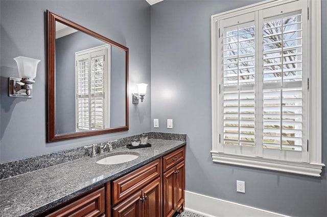 bathroom with healthy amount of natural light, vanity, and baseboards