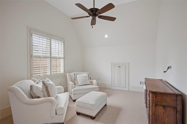 sitting room with vaulted ceiling, a ceiling fan, and carpet flooring