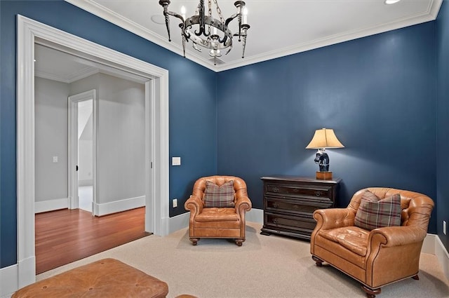 sitting room with a chandelier, crown molding, and baseboards