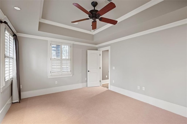 unfurnished bedroom featuring carpet flooring, crown molding, a tray ceiling, baseboards, and ceiling fan