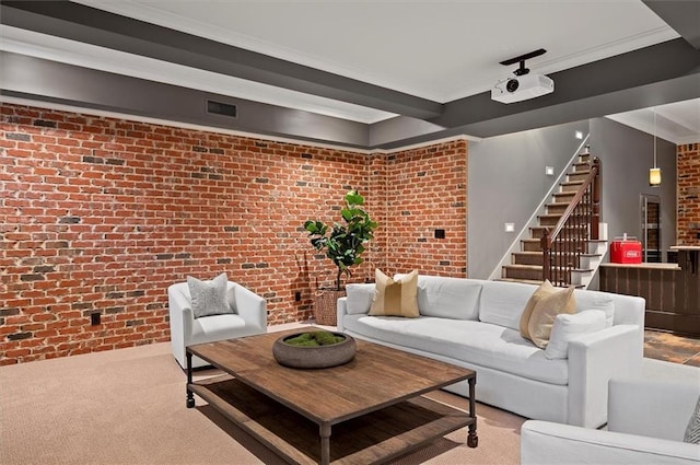 living room with brick wall, carpet, stairway, and crown molding