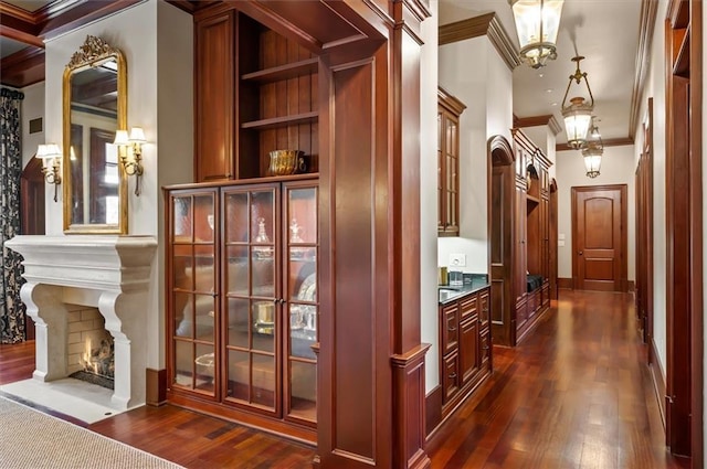 hall with crown molding, dark wood-style floors, and baseboards