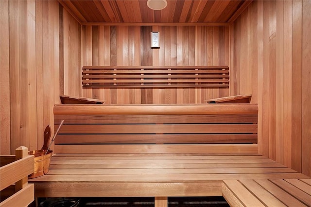 relaxing sauna featuring wooden walls and wood ceiling