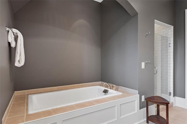 bathroom featuring a shower stall and a bath
