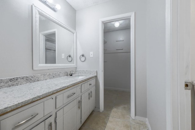 2173 Martin Way, Jonesboro, GA 30236 - bathroom with vanity, a textured ceiling, tile patterned flooring, baseboards, and a spacious closet