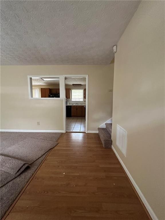 213 Peartree Ln, Riverdale, GA 30274 - hallway with a textured ceiling, wood finished floors, baseboards, and stairs