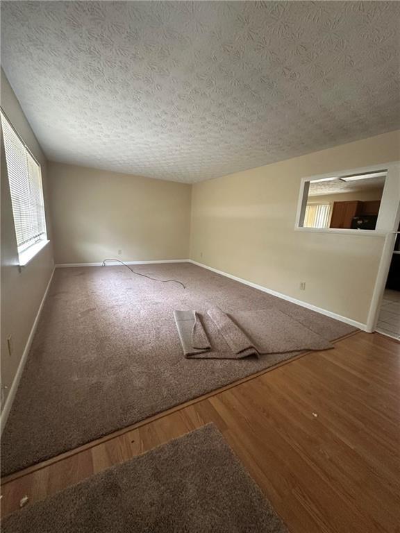 213 Peartree Ln, Riverdale, GA 30274 - empty room with baseboards, wood finished floors, and a textured ceiling