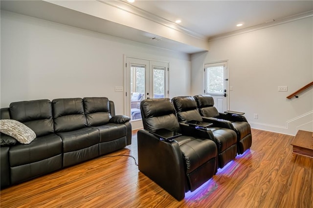 cinema featuring ornamental molding, light wood-type flooring, and french doors