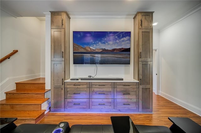 bar featuring ornamental molding and light hardwood / wood-style flooring