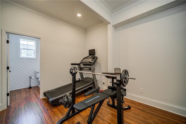 exercise room with dark hardwood / wood-style floors, crown molding, and tile walls