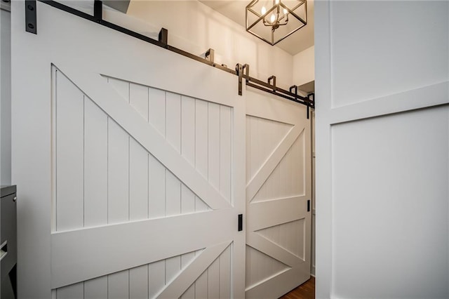 interior details featuring a barn door and an inviting chandelier