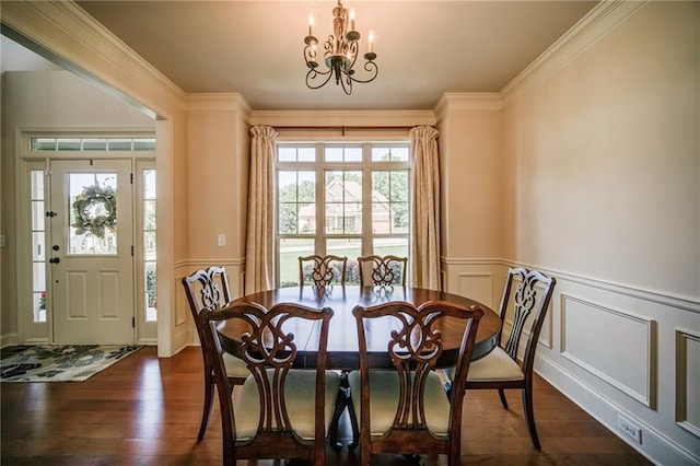 dining space with dark hardwood / wood-style flooring, a notable chandelier, ornamental molding, and plenty of natural light