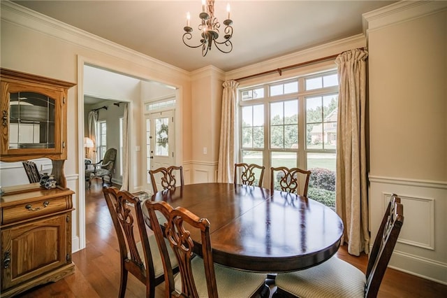 dining area with dark hardwood / wood-style floors, crown molding, and an inviting chandelier