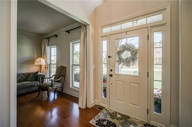 entrance foyer with plenty of natural light, dark hardwood / wood-style flooring, and crown molding