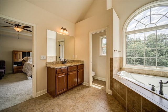 bathroom with ceiling fan, vanity, tile patterned floors, toilet, and vaulted ceiling