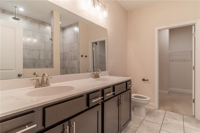 bathroom with vanity, tile patterned floors, toilet, and tiled shower