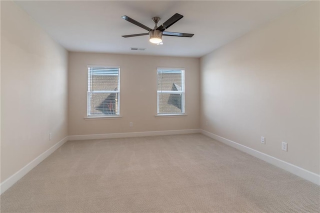 empty room with ceiling fan and light carpet