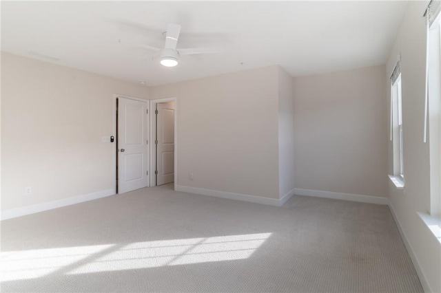 carpeted spare room with ceiling fan