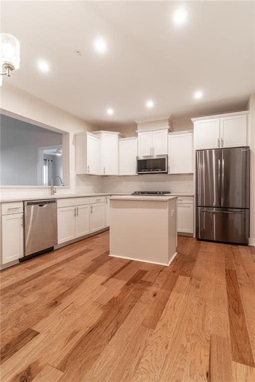 kitchen featuring stainless steel appliances, light hardwood / wood-style floors, and white cabinets