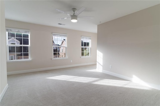 spare room featuring light colored carpet and ceiling fan