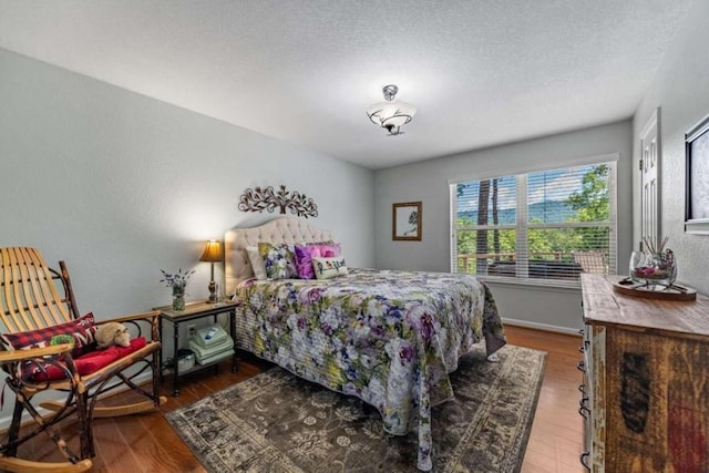 bedroom featuring a textured ceiling and wood-type flooring