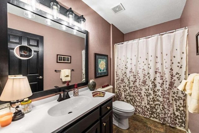 bathroom featuring tile patterned flooring, vanity, and toilet