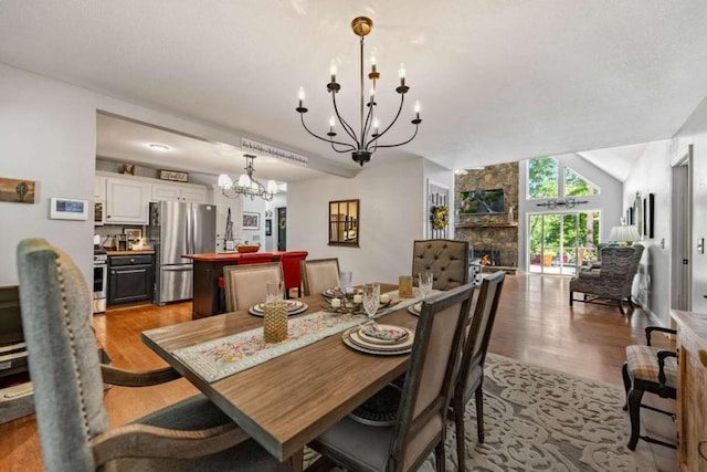 dining space with light hardwood / wood-style flooring, lofted ceiling, and a chandelier