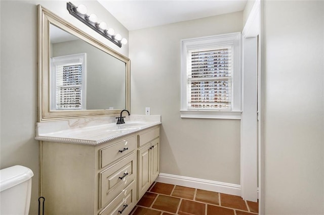 bathroom with vanity, toilet, and baseboards