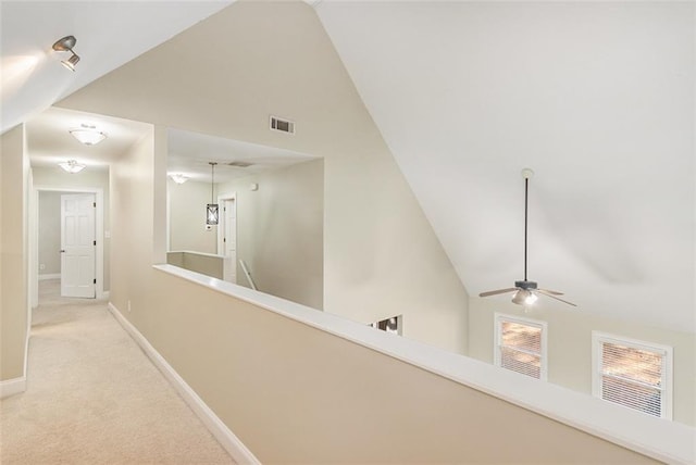 corridor featuring baseboards, visible vents, carpet flooring, an upstairs landing, and high vaulted ceiling