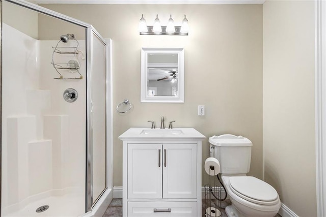 bathroom featuring a stall shower, baseboards, vanity, and toilet