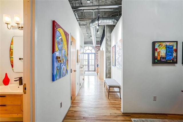 corridor with sink and light hardwood / wood-style flooring