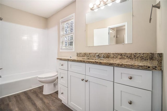 full bathroom with hardwood / wood-style flooring, vanity, shower / bathtub combination, and toilet